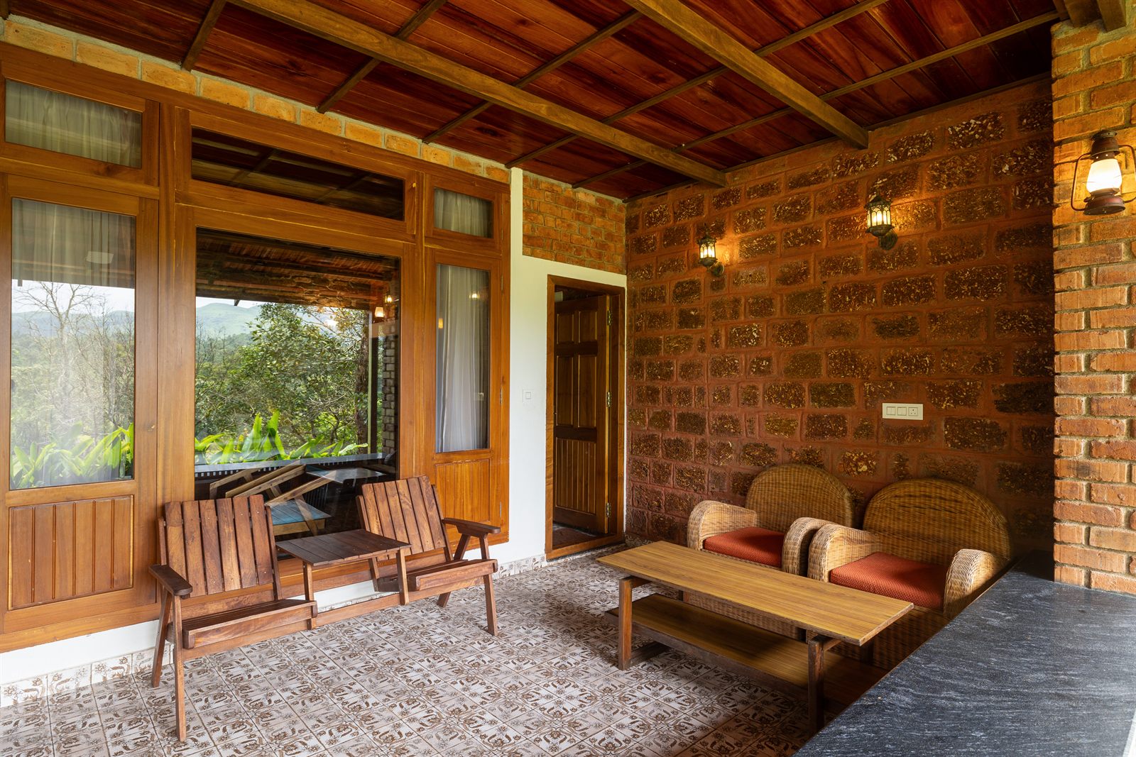 Covered porch seating with forest view at Chawarhakki Gudlu Cottage